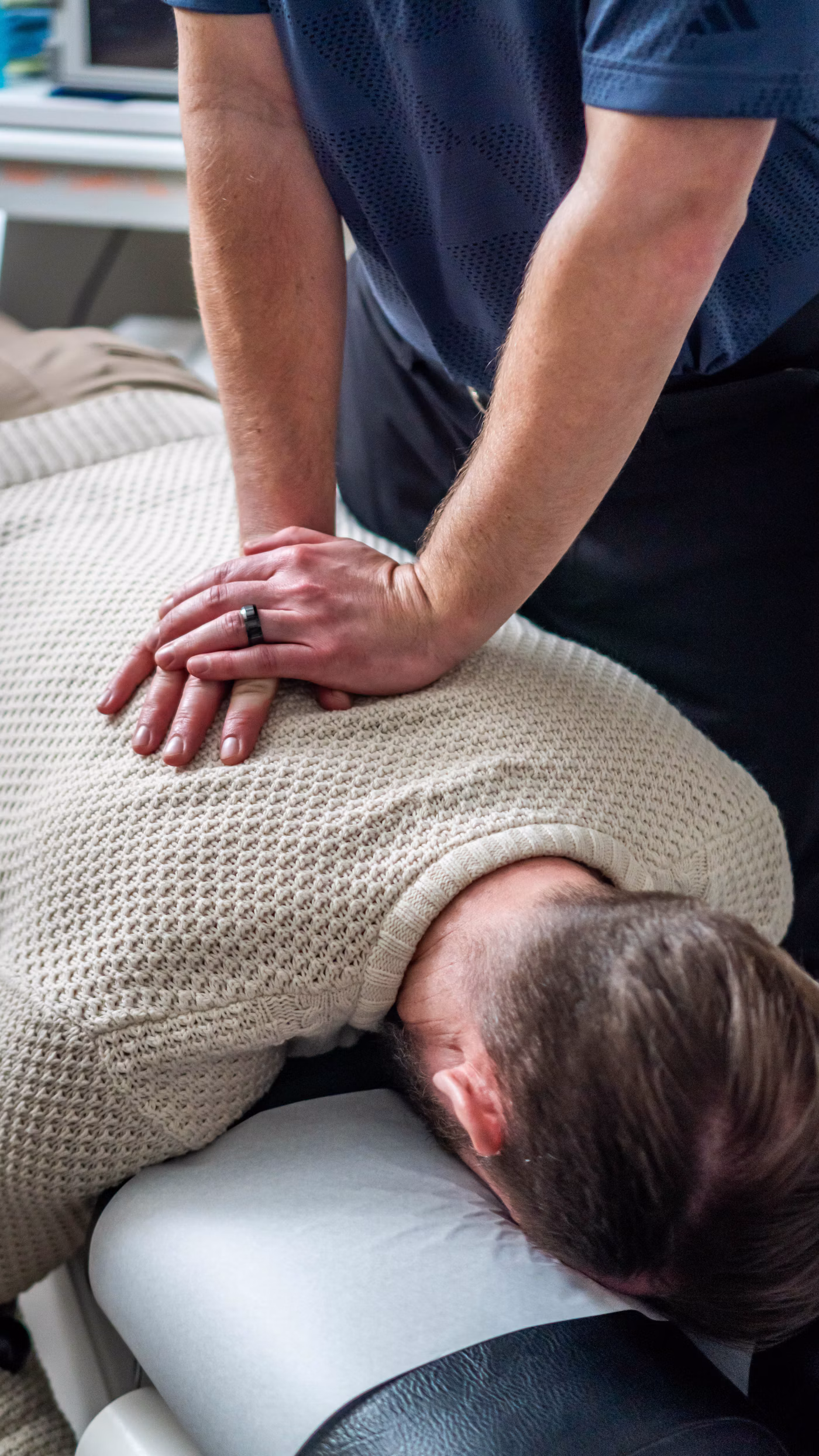 Atendimento hands on: terapia manual nas costas de um paciente